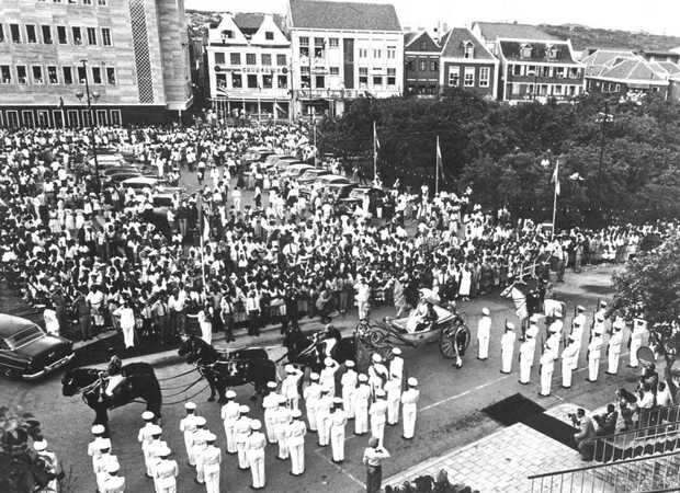 In 1955 - just after the Netherlands Antilles had become self governing in 1954 - Queen Juliana visited the islands. The picture shows the parade, in an open horse drawn carriage, in Willemstad on Curacao.